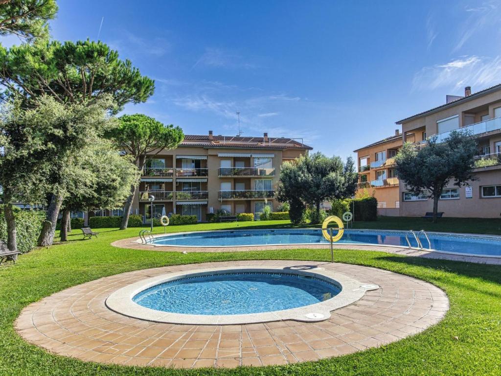 a swimming pool in a park with a building at Apartment Sa Guilla by Interhome in Pals
