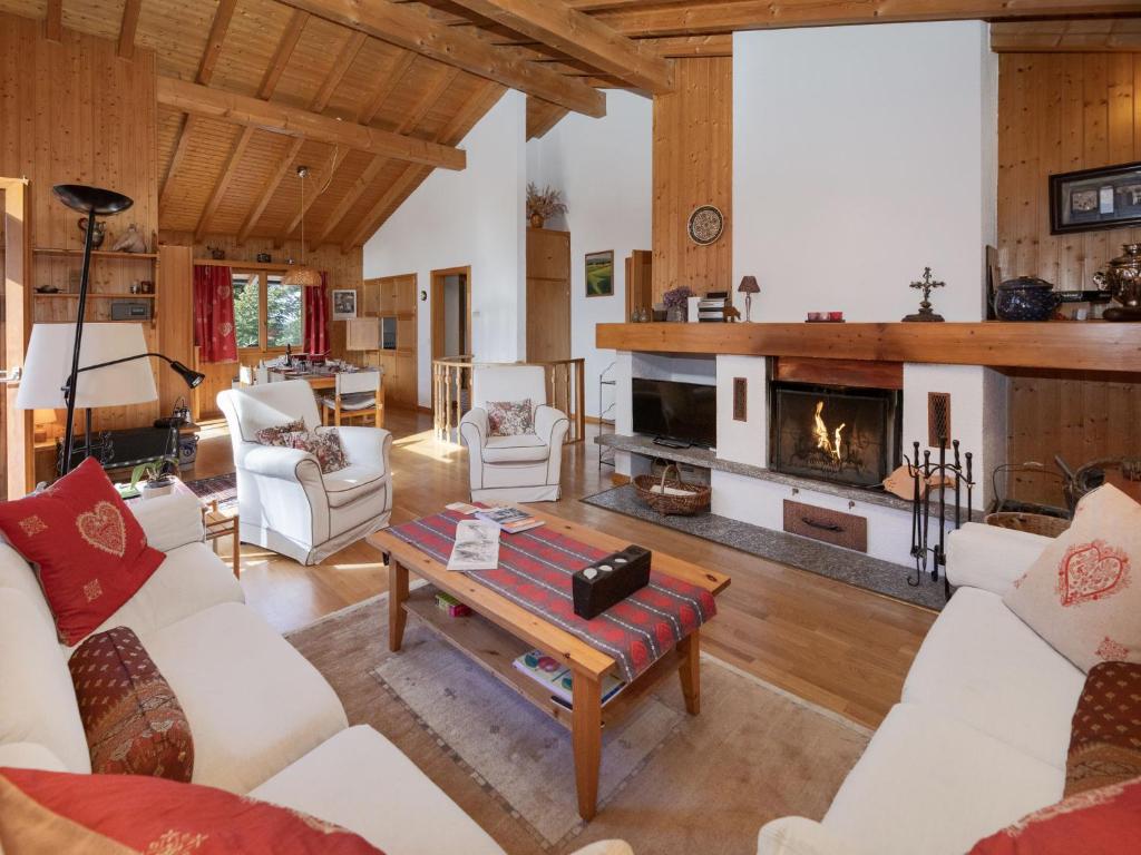 a living room with white furniture and a fireplace at Chalet Veni- Vidi- Mansi by Interhome in Champex