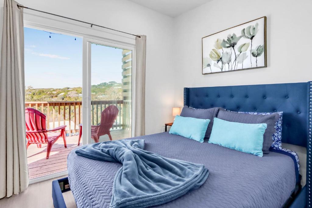 a bedroom with a blue bed and a balcony at The Container Retreat - 2B in Canyon Lake