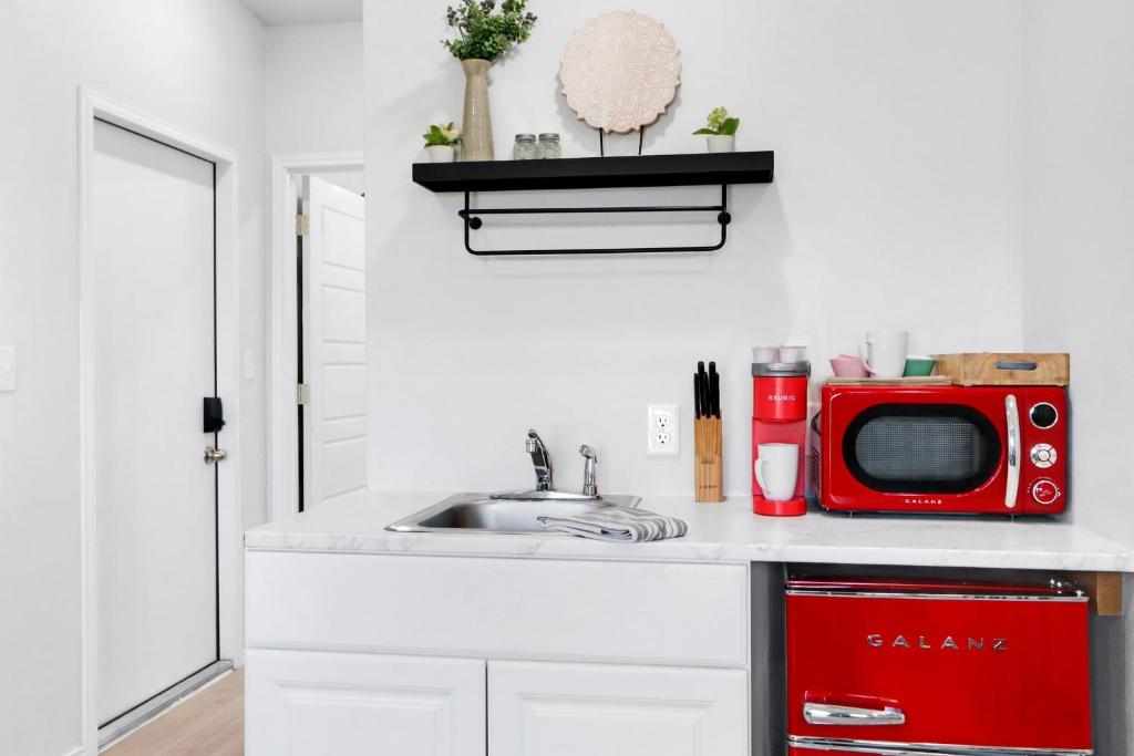 a kitchen with a sink and a red microwave at The Container Retreat - 2A in Canyon Lake