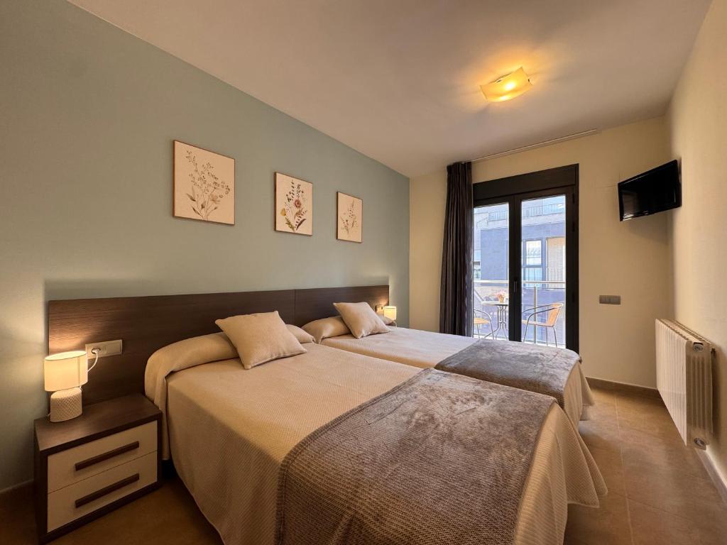a bedroom with a large bed and a balcony at Casa Polaco in Valderrobres