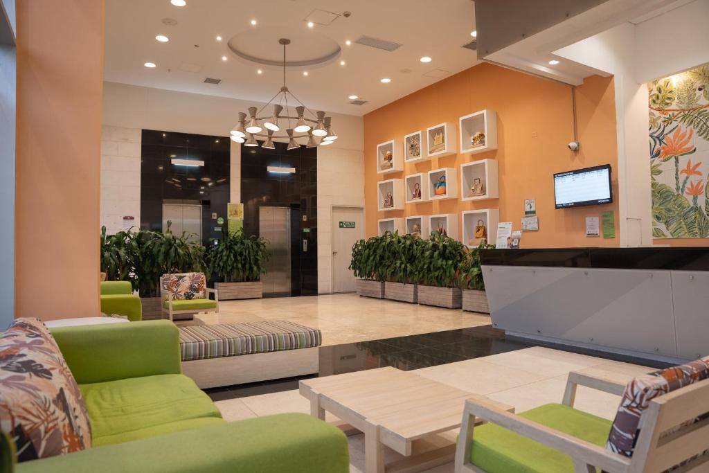 eine Lobby mit einem Wartezimmer mit grünen Stühlen und einem Tisch in der Unterkunft Mia Hotel Choco in Quibdó
