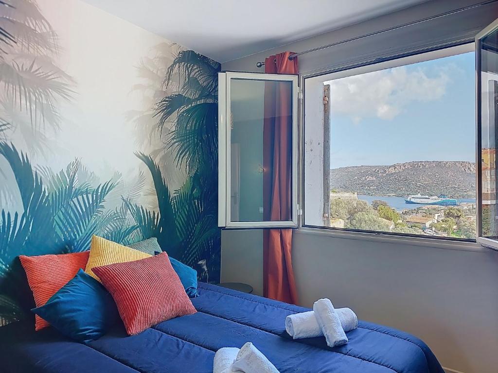 a blue couch in a room with a window at Apartment U Centru by Interhome in Porto-Vecchio