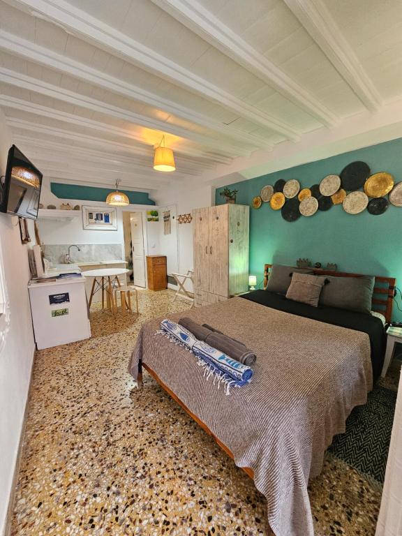 a bedroom with a bed and a kitchen with pans on the wall at Petra Pelikan in Mikonos