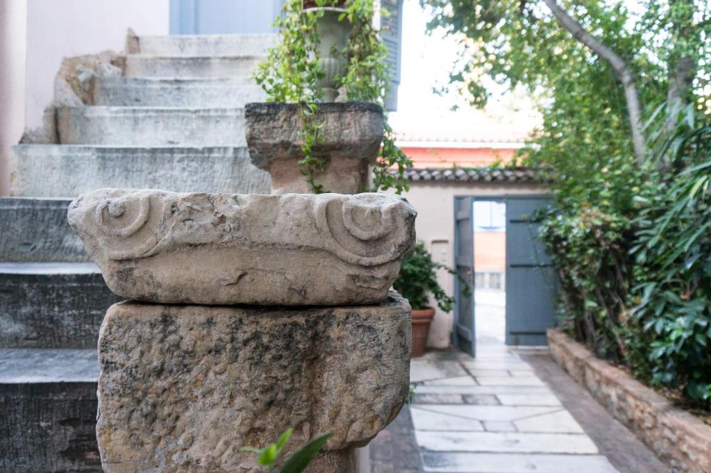a stone column in a courtyard with stairs at Acropolis Villa in Plaka in Athens