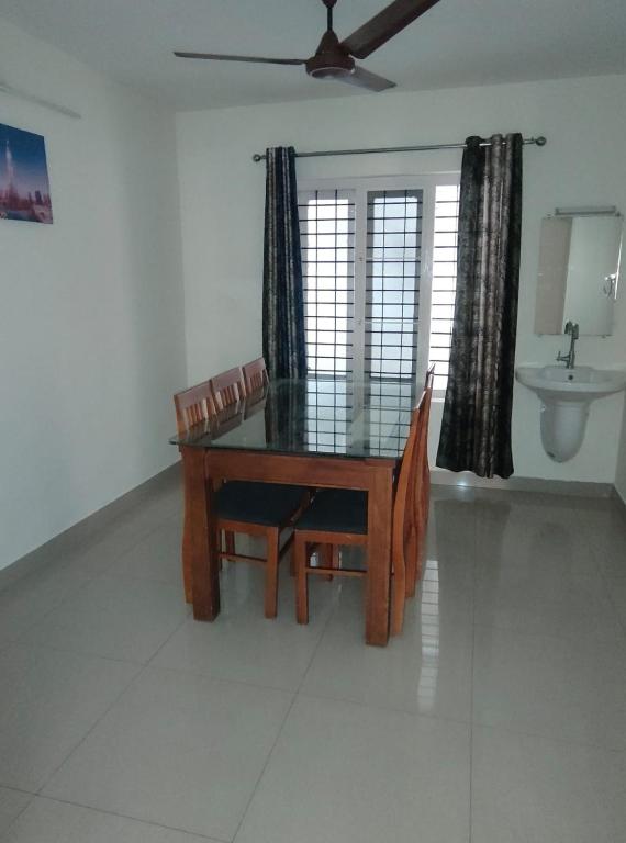 a dining room with a table and chairs and a sink at HK villas in Edappally