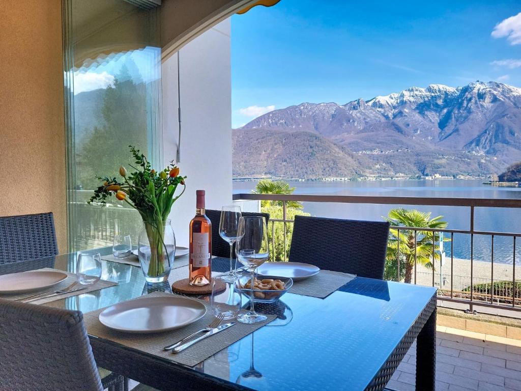 a dining table with a view of the water and mountains at Apartment Vico Morcote Luxury View Apartment by Interhome in Morcote