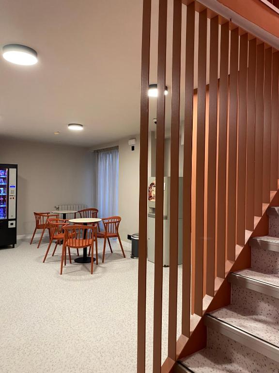 a room with a table and chairs and a staircase at Pensión Coral in Barcelona