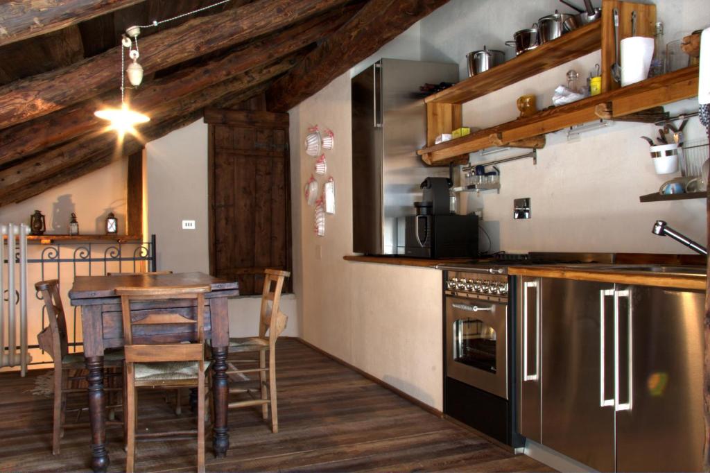 a kitchen with a table and a dining room at Baita del Plan in Pragelato