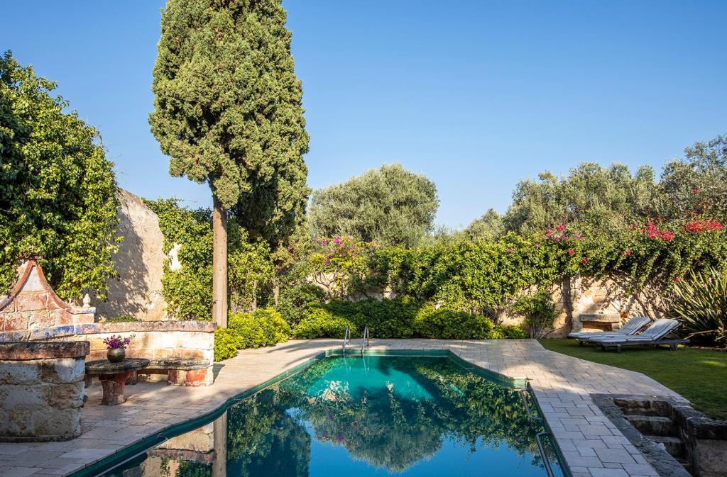 a swimming pool in a yard with trees at Masseria Buganvillea in Fasano