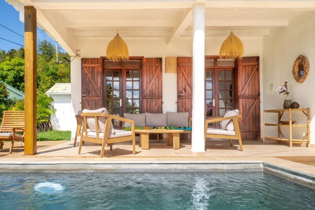 a villa with a swimming pool and a house at Villa Bleue Papaye in Grand-Bourg
