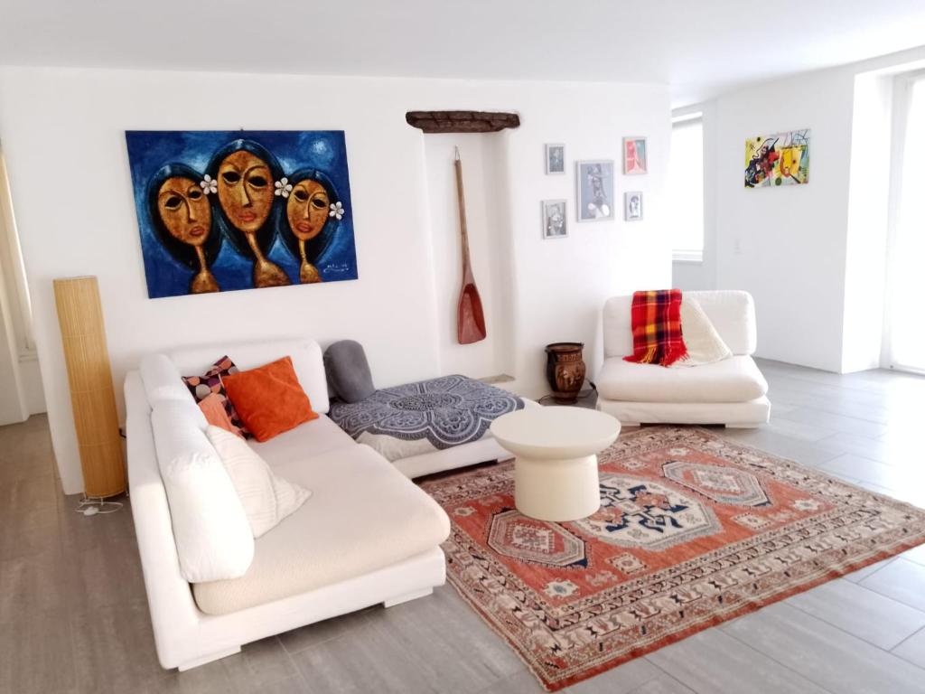 a living room with a white couch and a rug at Casa Edo in Ponte Tresa