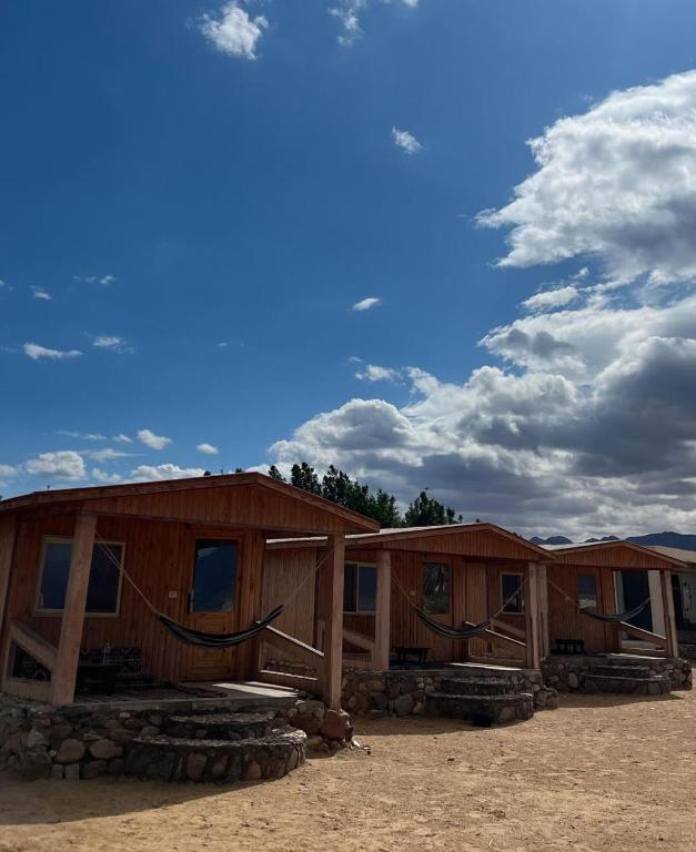 a row of wooden huts in a field at Heaven Dune Camp in Nuweiba