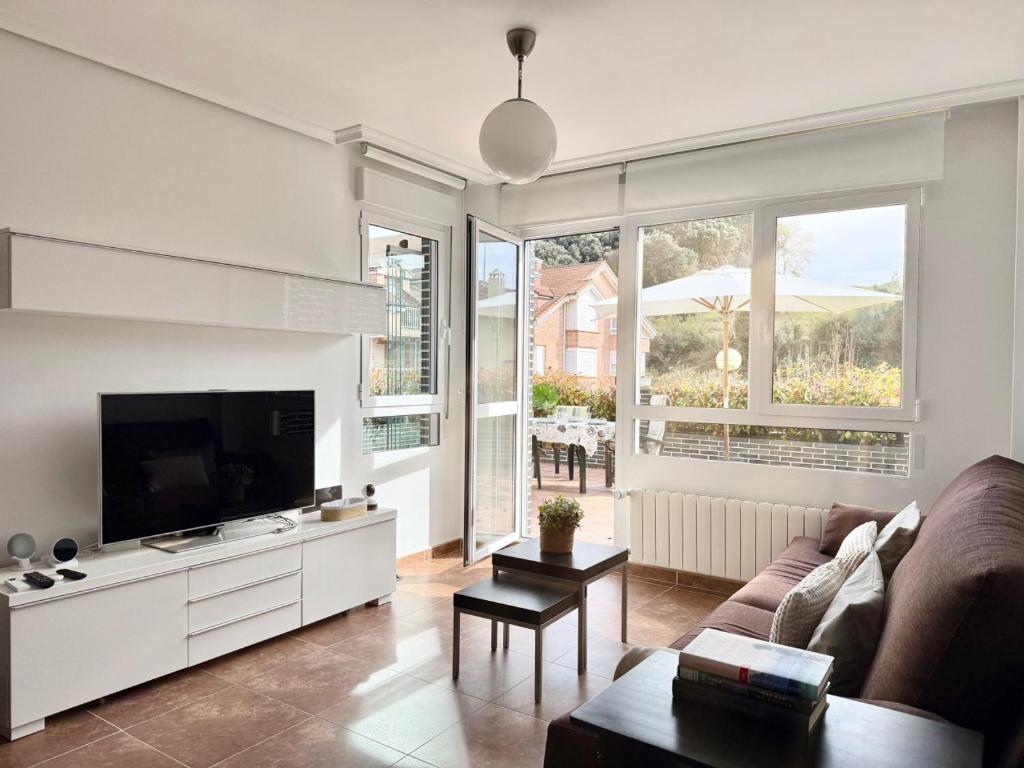 a living room with a couch and a flat screen tv at Casa El Robledal 5925 in Arnuero