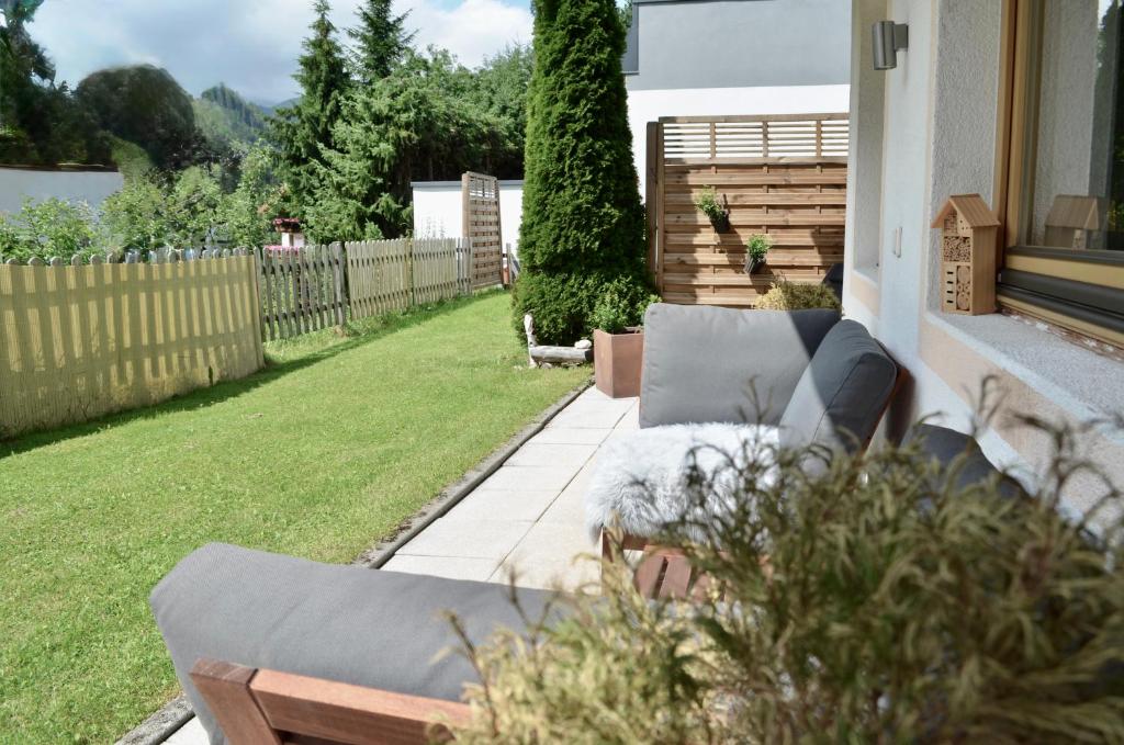 a patio with couches and a yard with a fence at Hollys Ferienwohnungen in Gerlos