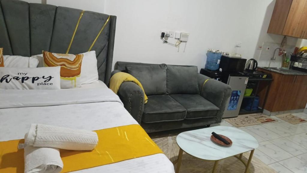 a living room with a bed and a couch at Heritage Homes in Ruiru