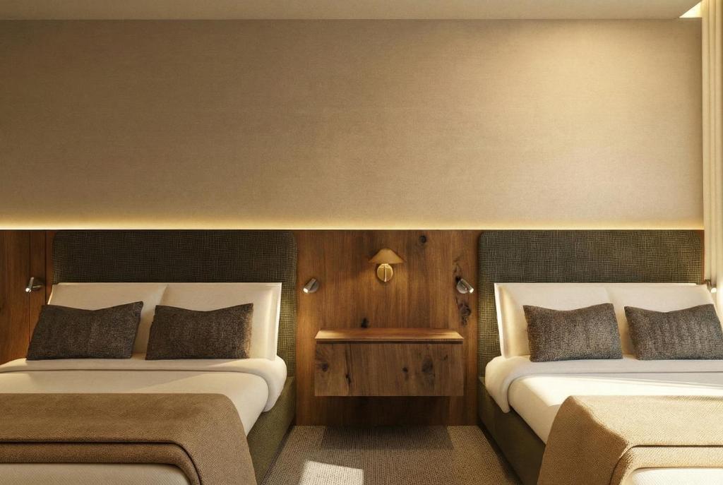 two beds in a small room with at Hotel Core Suites Estadio Akron in Zapopan
