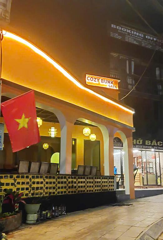 a restaurant with a flag in front of a building at Cozy Bunk Sa Pa in Sapa