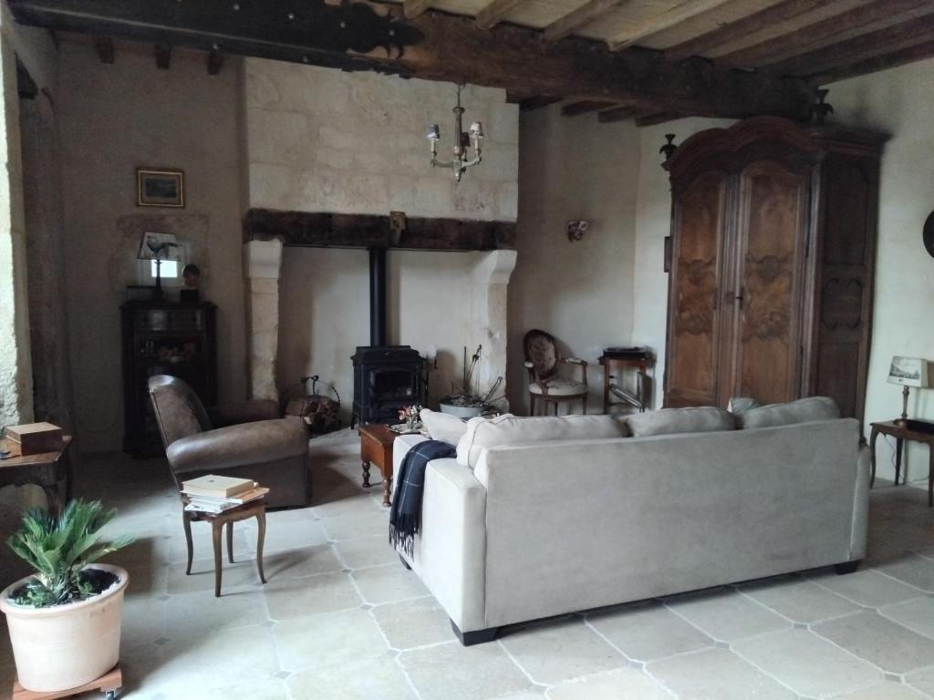 a living room with a white couch and a table at Les Hauts de la Crempse chambre d'hôtes in Montagnac-la-Crempse