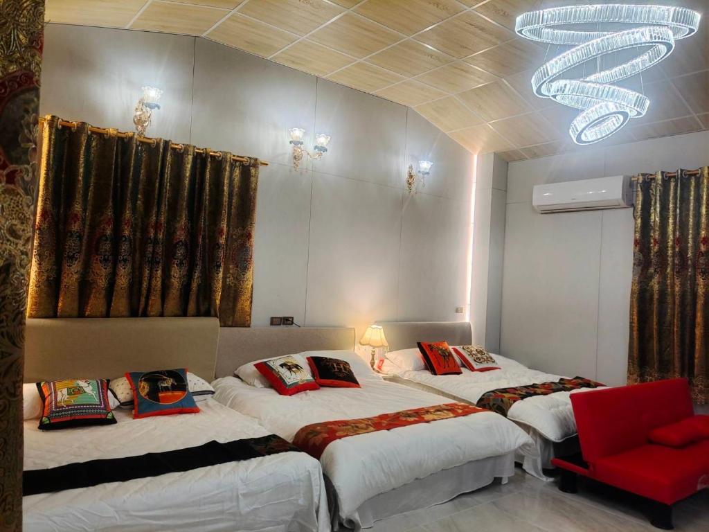 a room with two beds and a red chair at 湖山沐旅 Hu Shan Mulu in Douliu