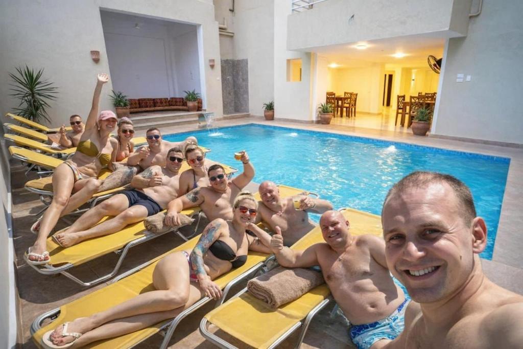 a group of people sitting on chairs in a swimming pool at Theban Hills Hotel, Luxor in ‘Ezbet Abu Ḥabashi