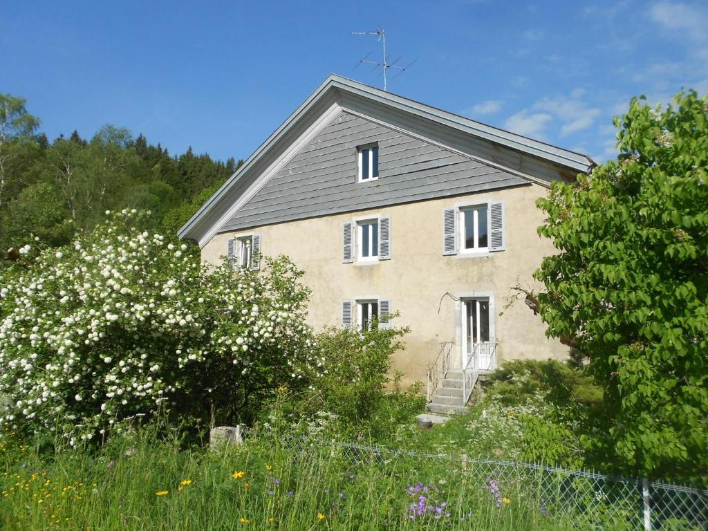 an old house with white flowers in front of it at Gîte Les Chamois 15 Personnes in Les Rousses