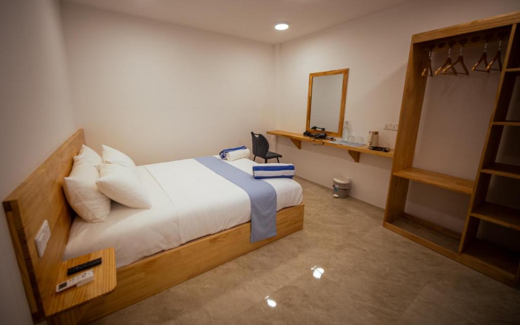a bedroom with a large bed and a mirror at Buceo Inn Mathiveri in Mathiveri