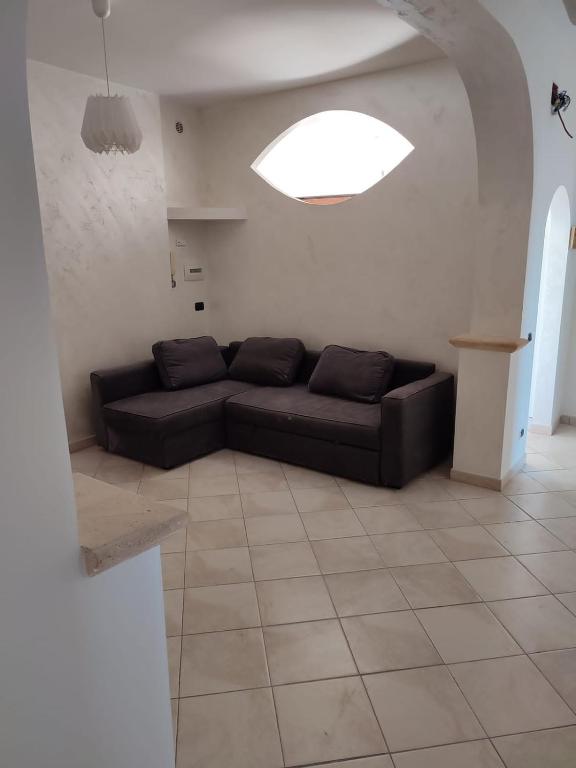 a living room with a black couch in a room at Casa Mare Relax e Cortesia in Ardea