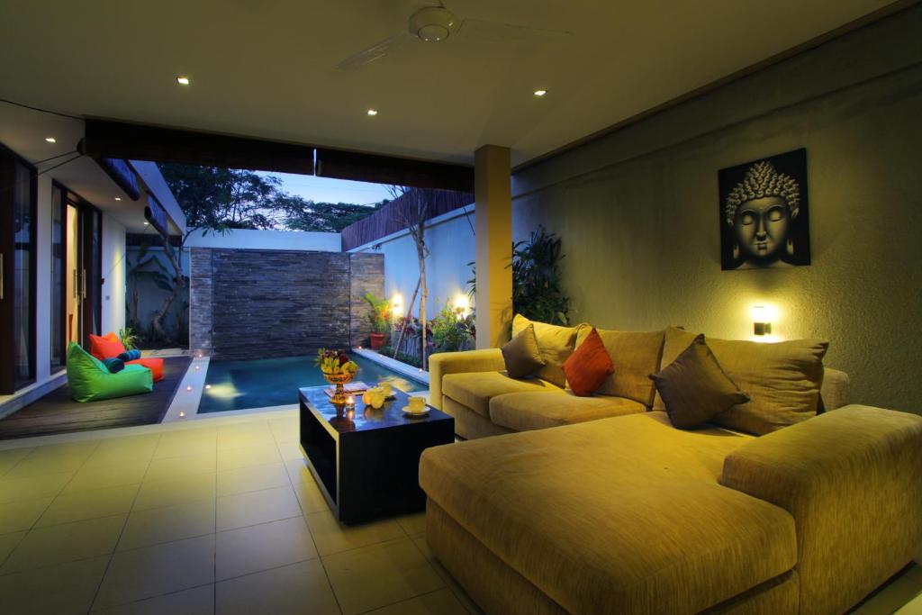 a living room with a couch and a table at Sudha Villa Bali Baik-Baik in Seminyak