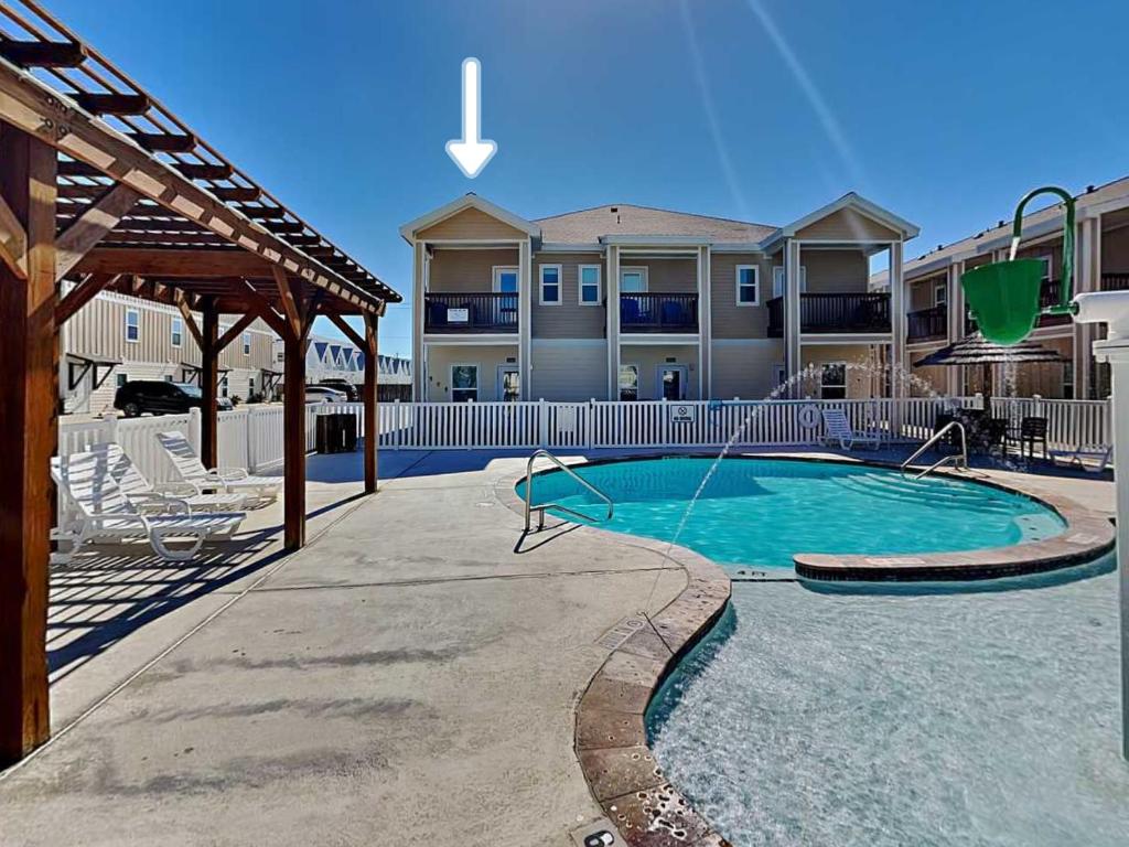 a swimming pool in front of a building at Trestles in Padre Island