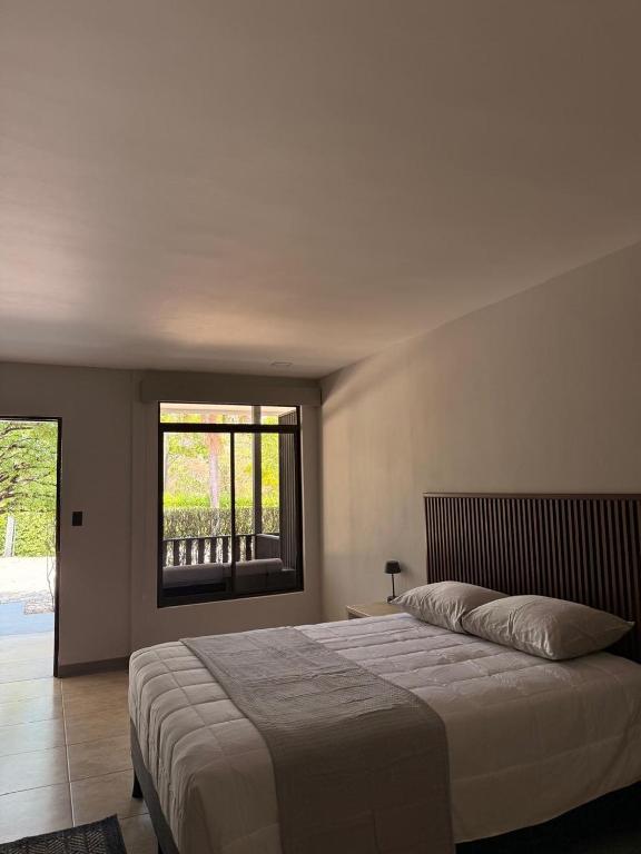 a bedroom with a large bed and a window at Guayacan Real Deluxe in Nicoya