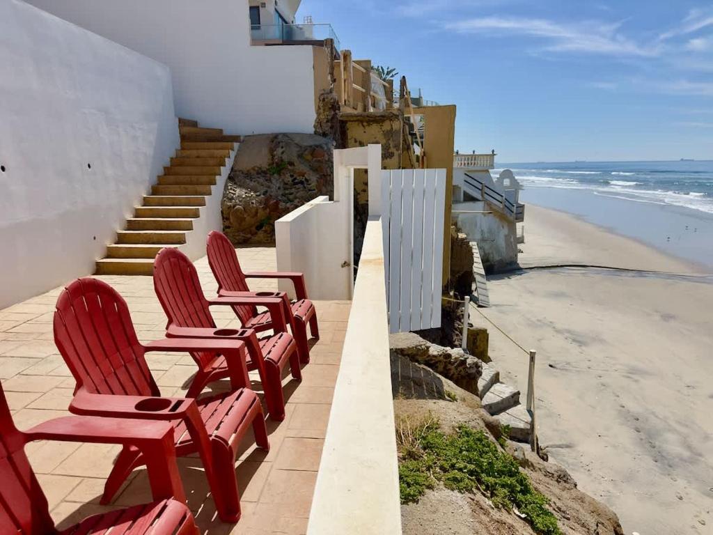 a row of red chairs sitting on the beach at San Antonio Del Mar - Beachfront Studio for Two in San Antonio del Mar