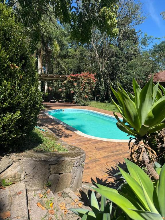 a swimming pool in a yard with trees at Villa Tuiuty Pousada de Charme in Bento Gonçalves