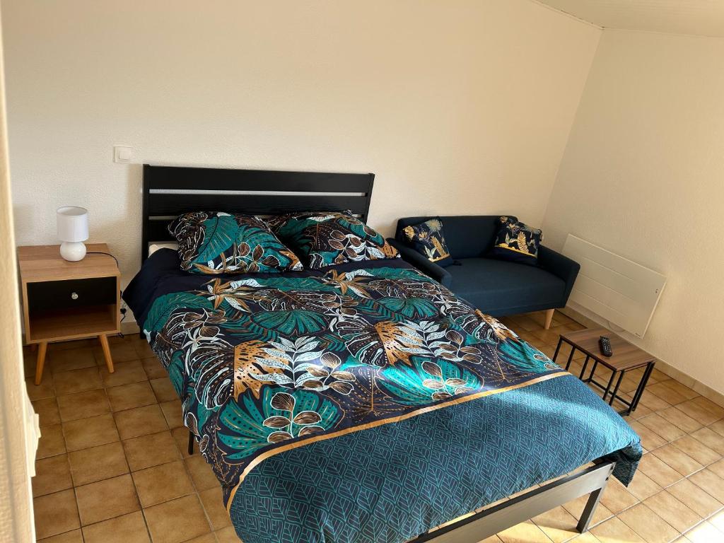 a bedroom with a bed and a couch at Studio Le Vale - Centre Ville de Givet in Givet