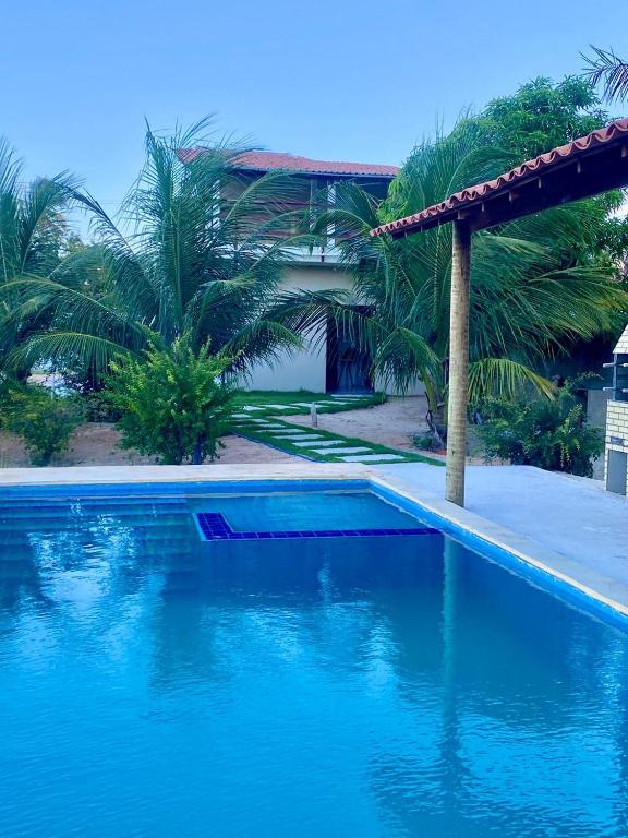 a swimming pool in front of a house with blue water at Refugio tropical icarai in Icaraí
