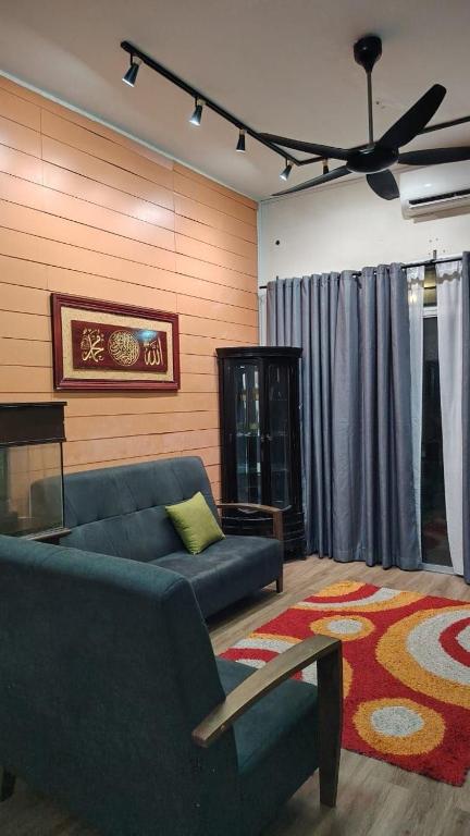 a living room with a blue couch and a piano at MQ Homestay in Temerloh