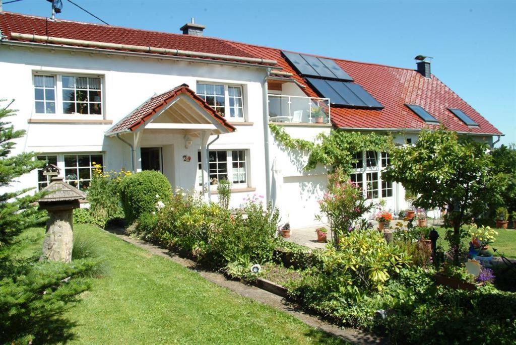 a white house with solar panels on the roof at Ferienwohnung Ferien im Dorf in Bleckhausen