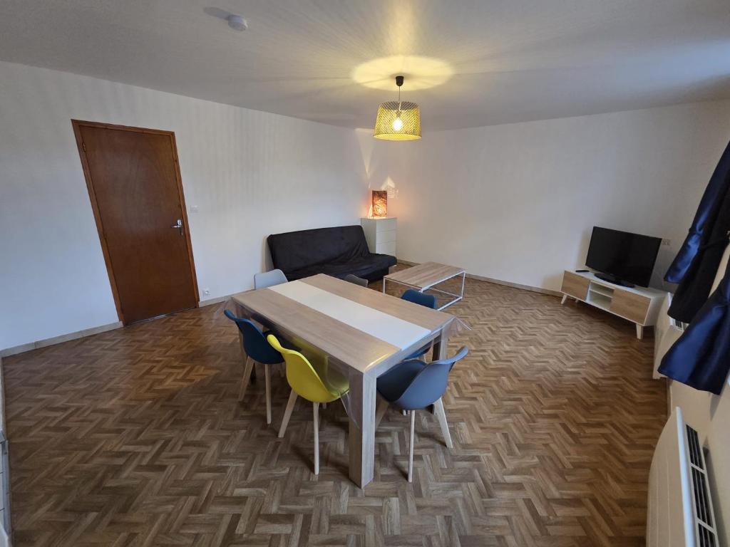 a room with a table and chairs and a couch at Appartement Le Gwen - Centre Ville de Givet in Givet