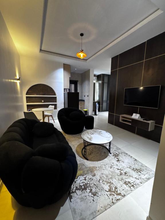 a living room with black furniture and a tv at U&U place in Uyo
