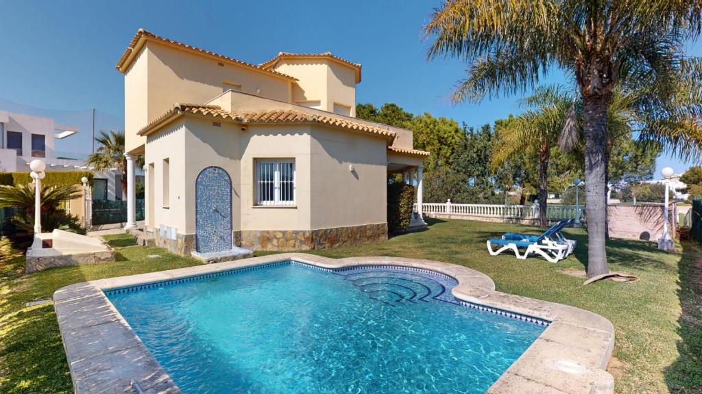 a villa with a swimming pool in front of a house at Greenview Villa by ON Travel in Oliva