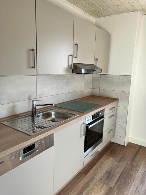 a kitchen with white cabinets and a sink at Ferienwohnung Erhol Dich Gut in Diez