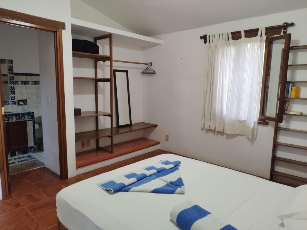 a bedroom with a bed with blue pillows on it at Habitacion Sol in Puerto Escondido
