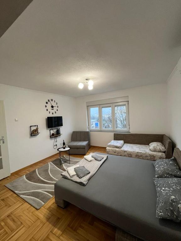 a bedroom with a large bed and a couch at Apartman Spaja in Trebinje