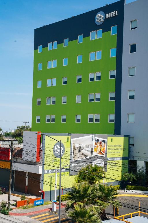 ein großes Gebäude mit einer grün-gelben Fassade in der Unterkunft SR Hotel in Guadalajara