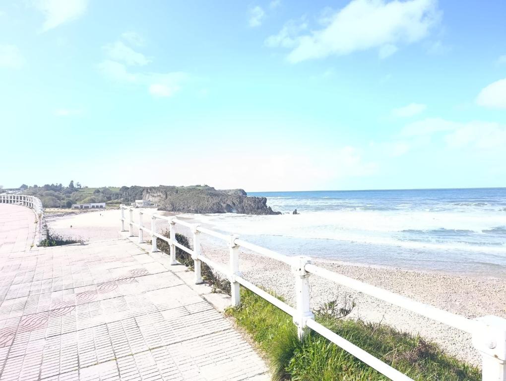 a boardwalk leading to a beach with the ocean at La Escapada, muy cerca de Llanes in Llanes