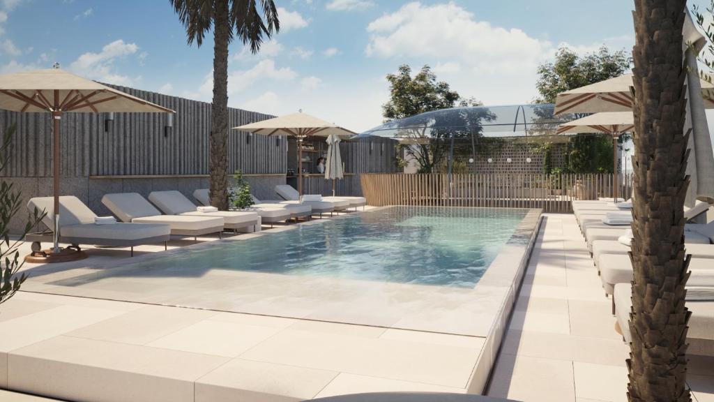 a swimming pool with lounge chairs and umbrellas at The Bank by MYR Hotels in Valencia