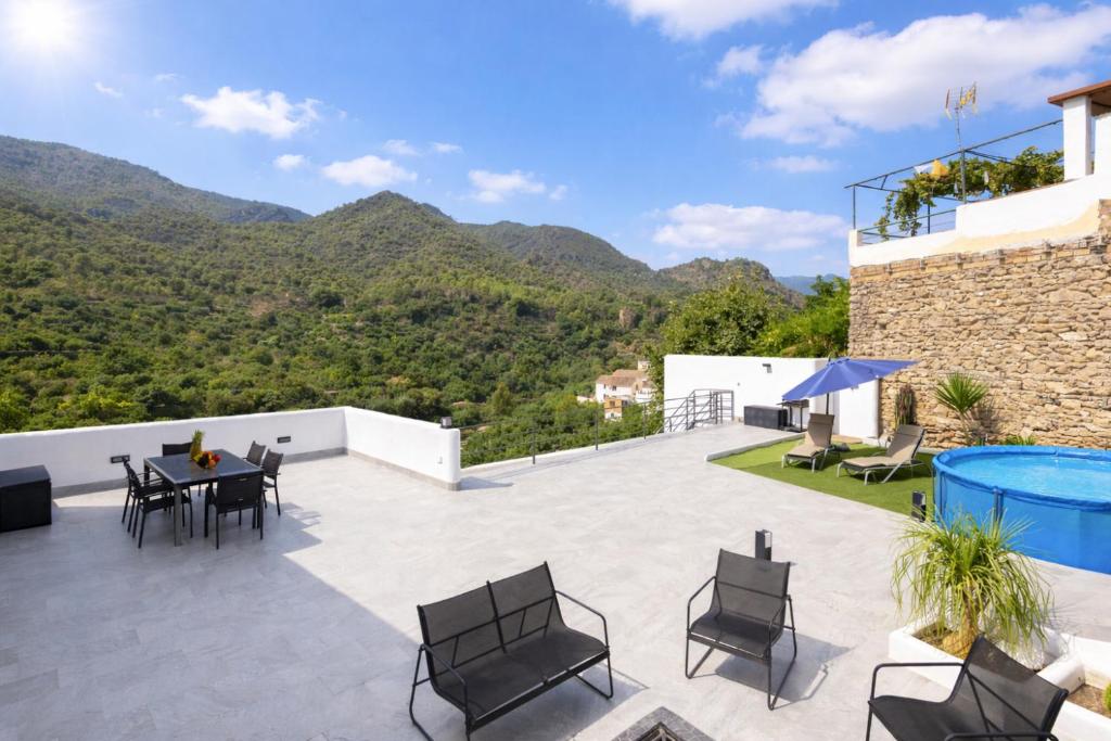 a patio with a table and chairs and mountains at Comeback el Rinconcito de Guajar in Guájar-Faragüit