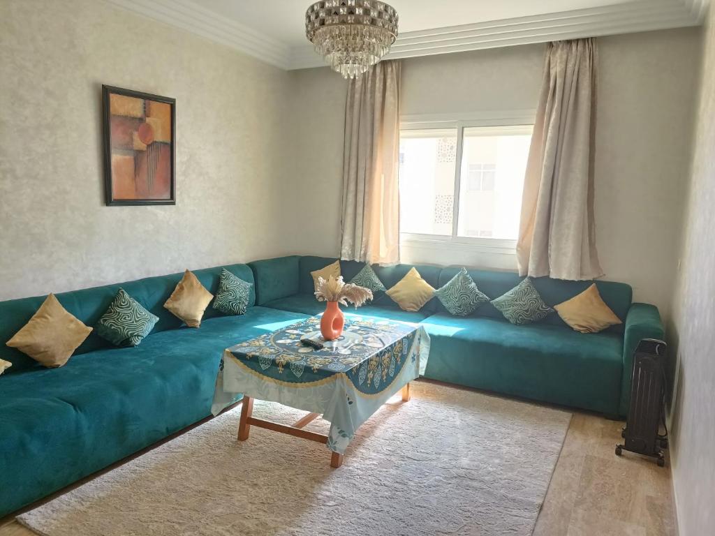 a living room with a blue couch and a table at Cosy appart 3p in Rabat