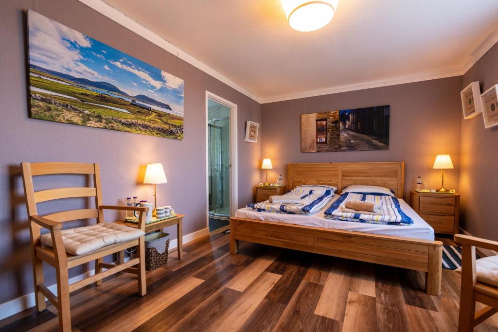 a bedroom with a bed and a chair at Orkney Bed & Whisky in Orphir