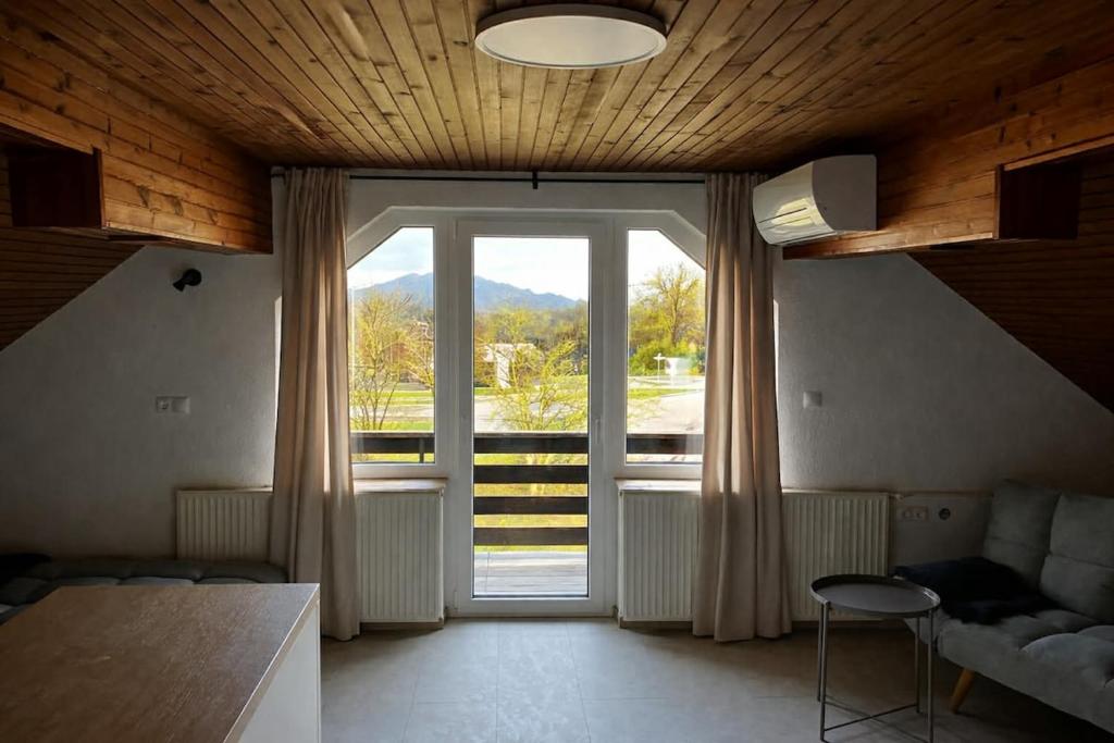 a living room with a large window and a couch at Apartments Lajk in Lesce
